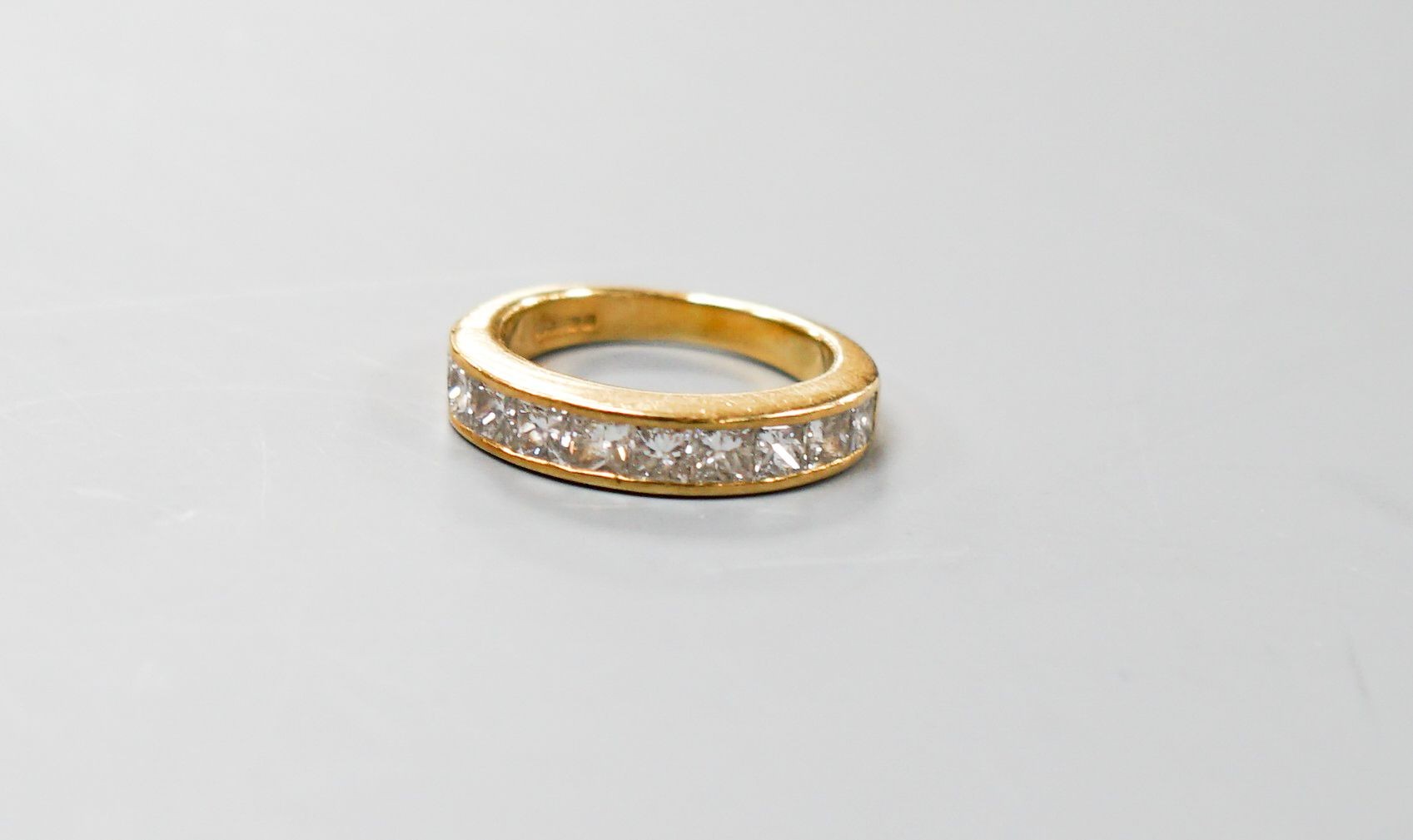 A modern 18ct gold and ten stone Princess cut diamond set half eternity ring, size I, gross 5.4 grams.